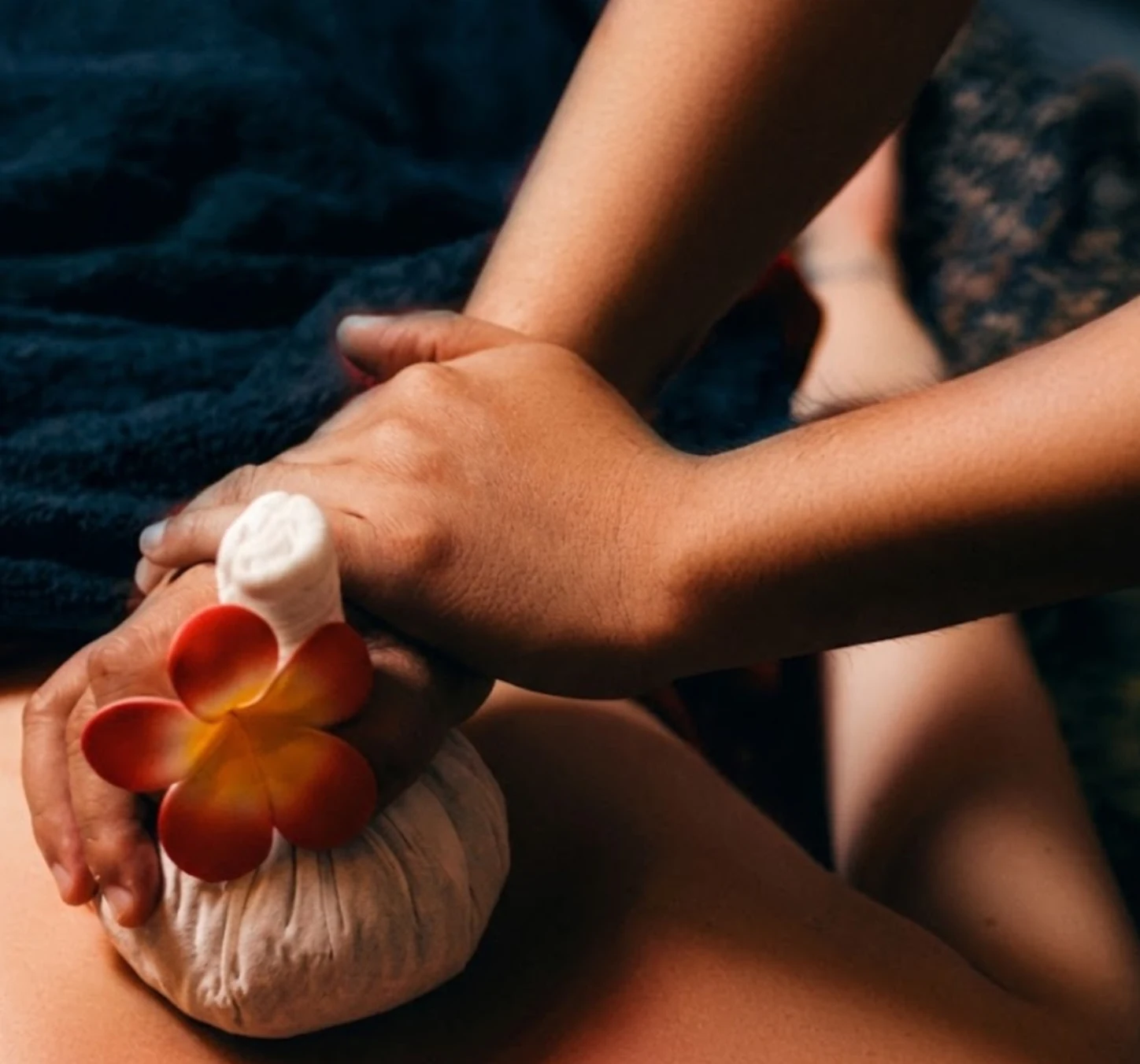 Therapist applying a Thai herbal compress during a therapeutic massage at Loft Thai Spa Bangkok