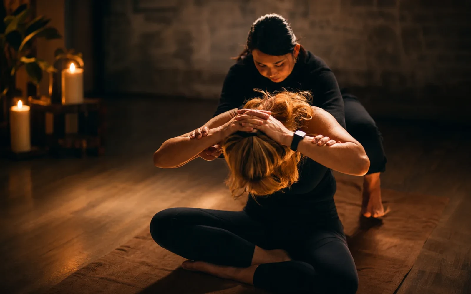 Practitioner supporting a dynamic seated Thai massage movement