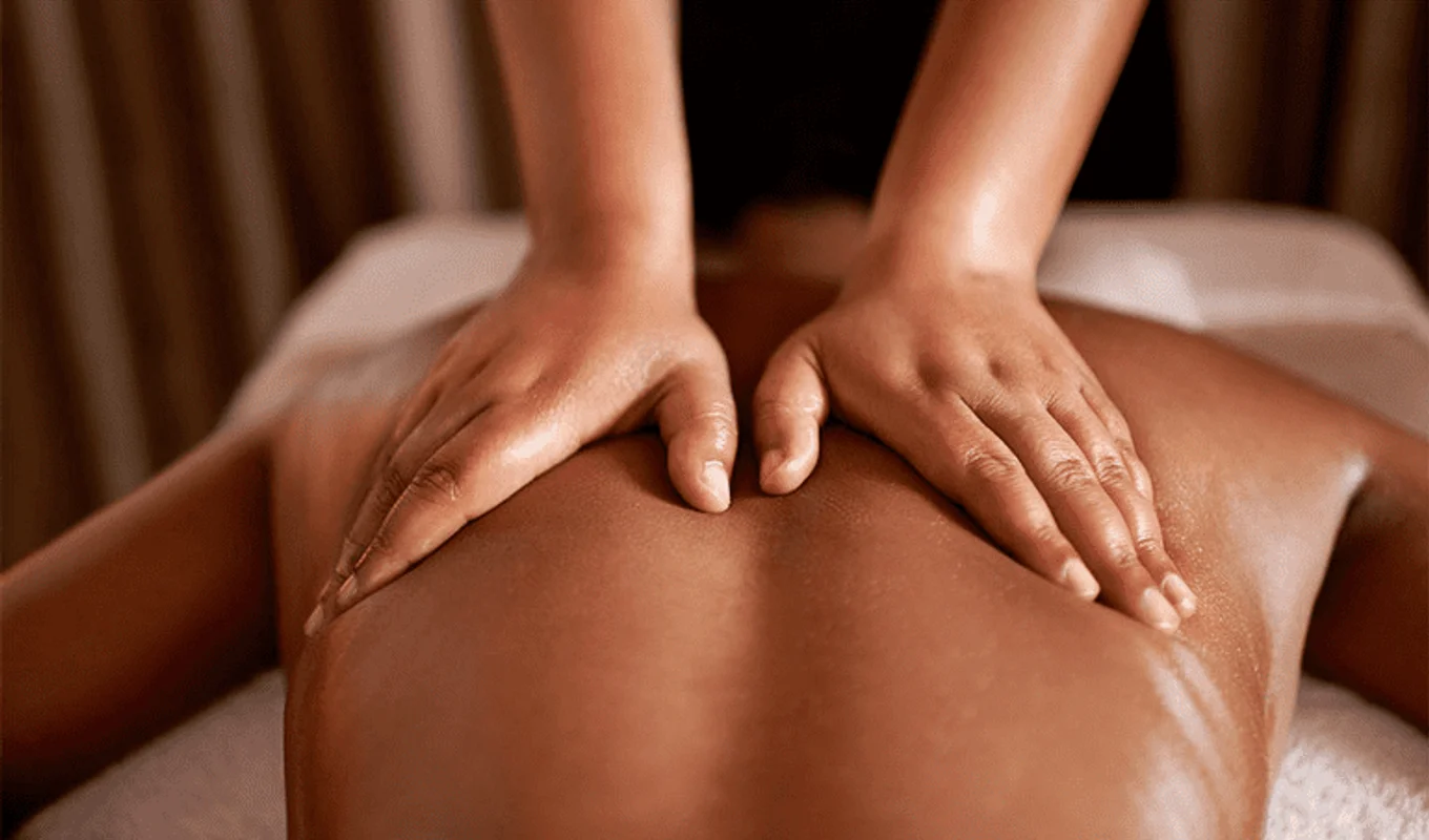 Close view of a therapist applying broad hand pressure during Swedish massage